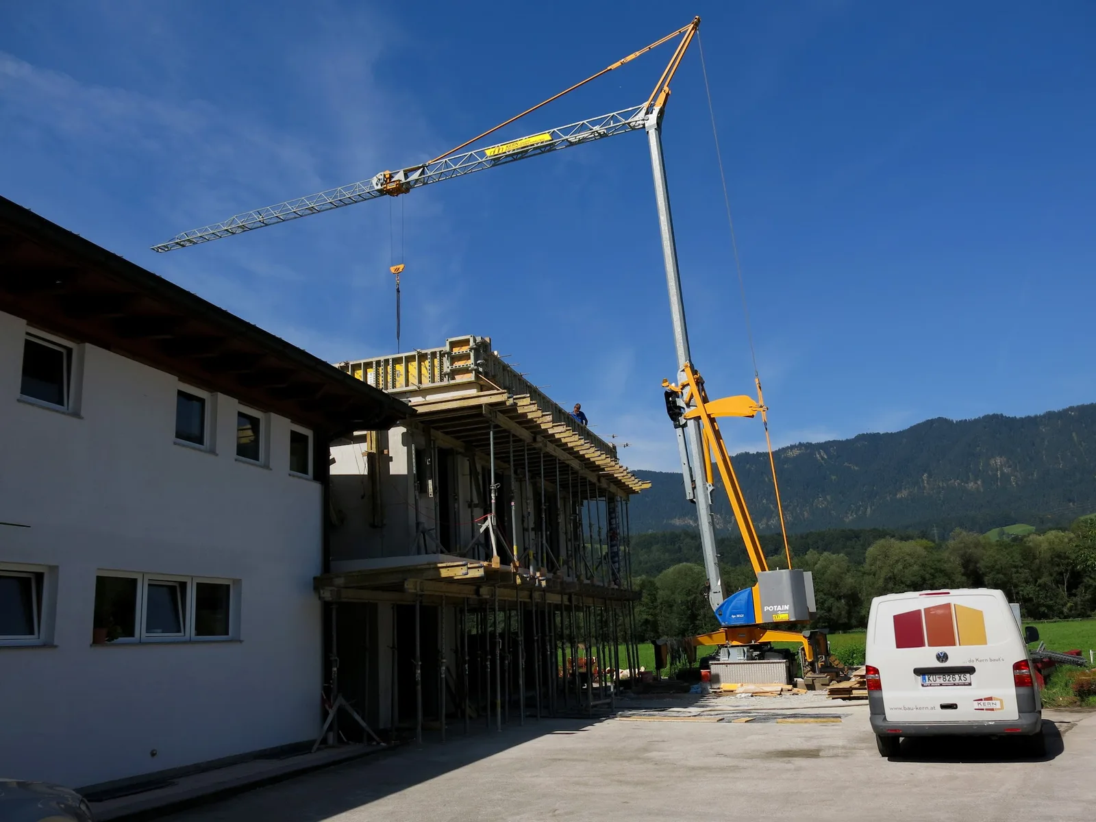 Baustelle mit Kran und beschriftetem Firmenfahrzeug von Kern Bauunternehmung